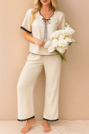 Apricot contrast-piped pajama set with gathered tie-neck top, scalloped lace finishes and straight-leg pants — front view