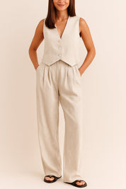Front view of an apricot sleeveless V-neck vest and pleated wide-leg pants set with button closure and side pockets.