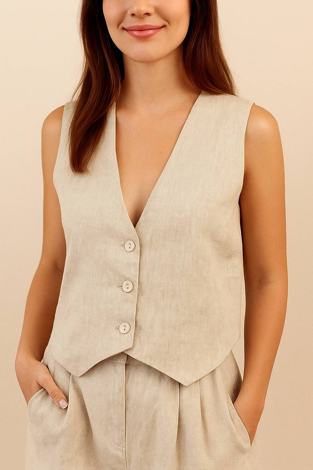 Front detail view of the apricot set showing the vest’s button closure and pleated trouser waist.