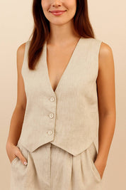 Front detail view of the apricot set showing the vest’s button closure and pleated trouser waist.
