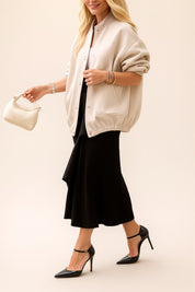 Full-length front three-quarter view of the apricot textured bomber jacket with snap front, drop-shoulder sleeves and elastic hem