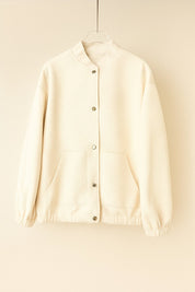 Hanger flatlay, front view of the apricot textured snap-button bomber jacket with rib-knit collar, patch pockets, elastic cuffs and hem.