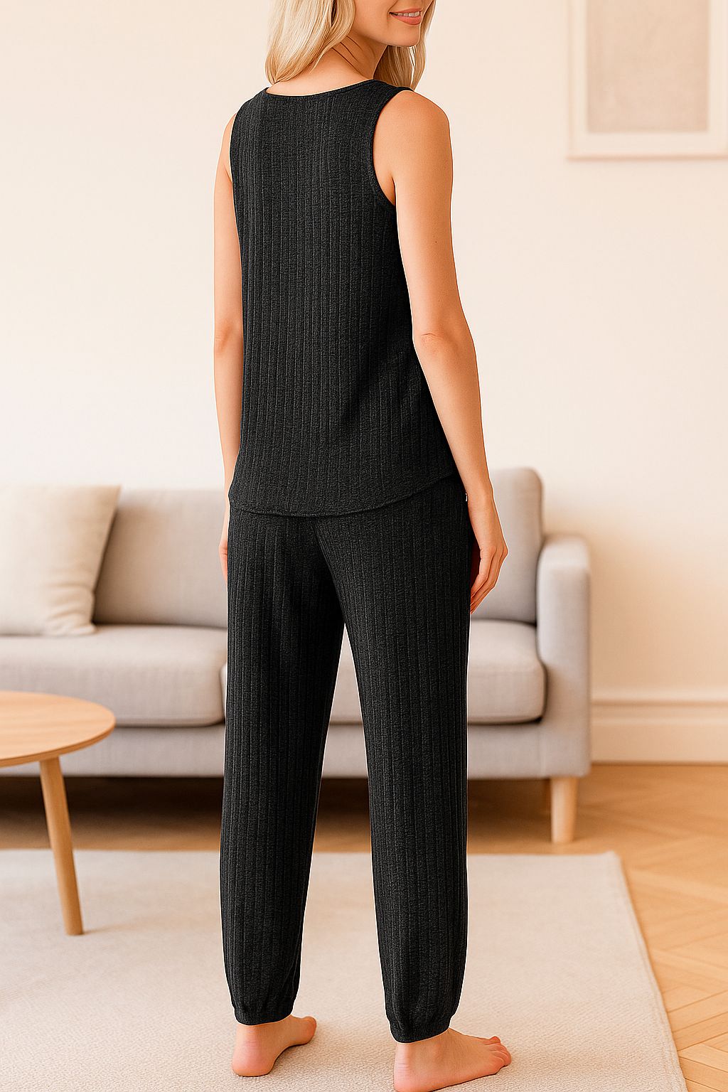 Back view of women's black ribbed knit loungewear pajama set with sleeveless top and cuffed pants