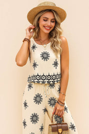 Front detail view of the beige sleeveless printed top showing the drawstring waist and border print at the hem; matching wide-leg trousers.