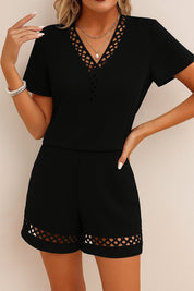 Straight front view of the black V-neck eyelet-trim top and shorts set with relaxed drape and hem eyelet bands.