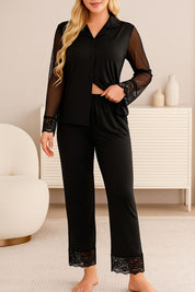 Full view of a woman wearing a black pajama set with lace trim sleeves and pants, featuring sheer mesh details and lapel collar