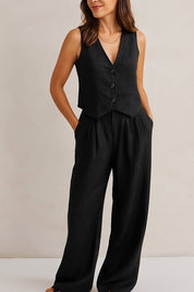 Front three-quarter view of the black vest and wide-leg pants set; V-neck, buttons and side pockets visible.