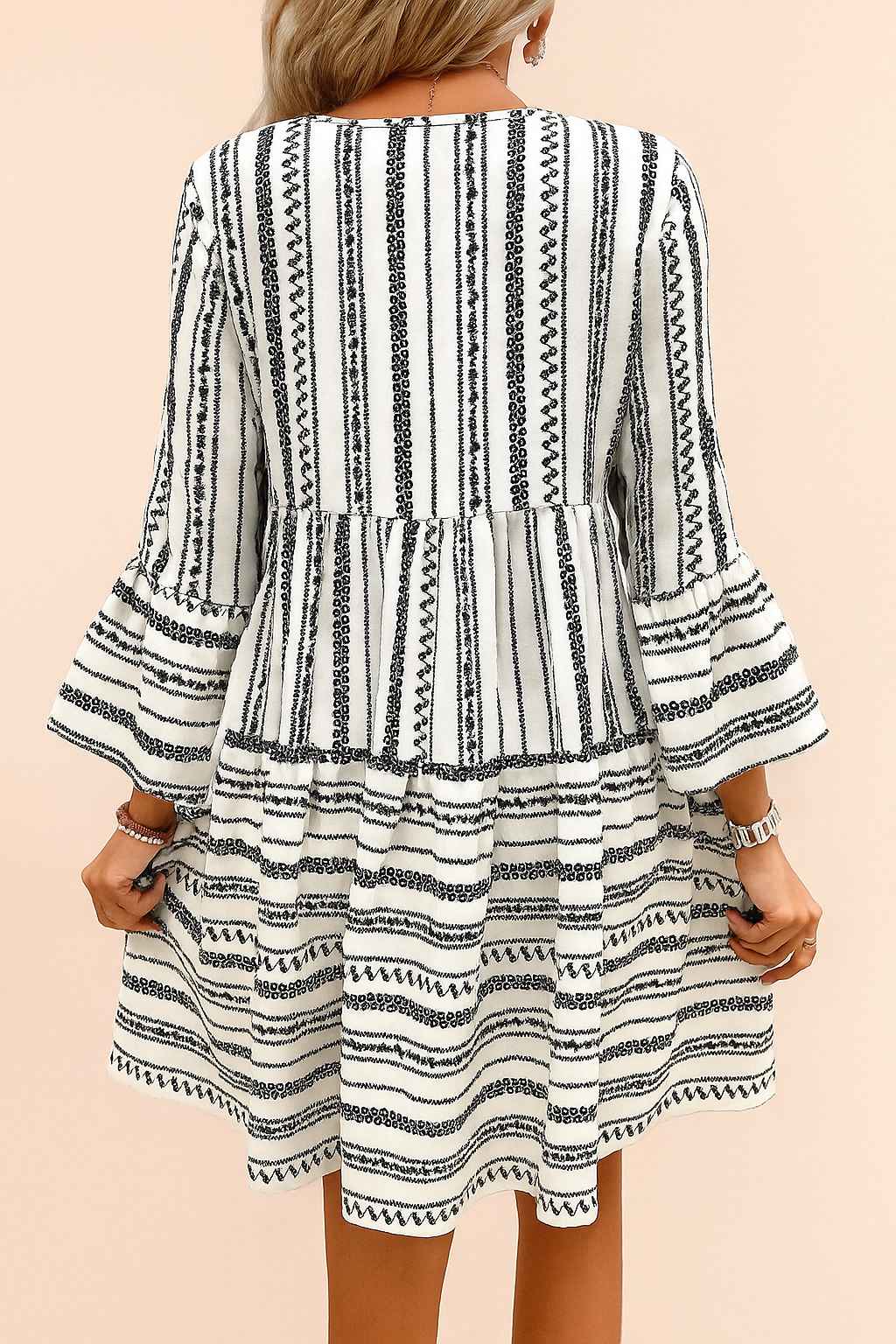 Black-and-white boho-print tie-neck mini dress with three-quarter flounce sleeves and clean back panel — back view.