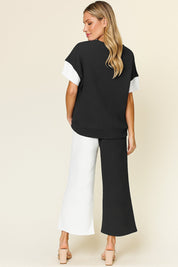 Back view of the black and white colorblock textured top and wide-leg pants set; straight back hem and elastic-waist trousers.