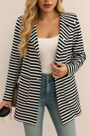 Centered front view of the black-and-white striped hooded snap-button long jacket with notched lapel, snap front and patch pockets.