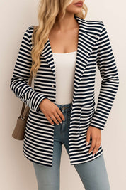 Front view of the black-and-white striped hooded snap-button long jacket worn open; notched lapel and patch pockets visible.