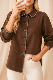 Front detail view highlighting the contrast whipstitch trim, shirt collar and button arrangement on the brown faux-suede jacket.