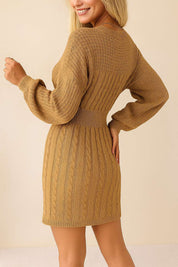Back view of the cable-knit sweater dress in camel brown highlighting the cable texture, ribbed waistband and mini-length hem