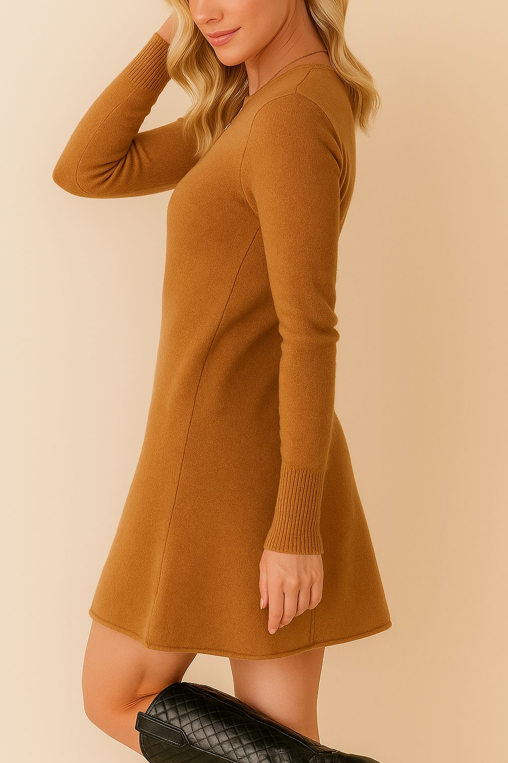 Left side profile of the camel brown knit sweater dress showing the fine-gauge texture, slim long sleeves with ribbed cuffs and a gently flared A-line mini hem for easy movement.