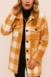 Front detail view of a women’s camel-and-ivory buffalo-check button-front coat with a shirt collar, long sleeves and flap chest pockets