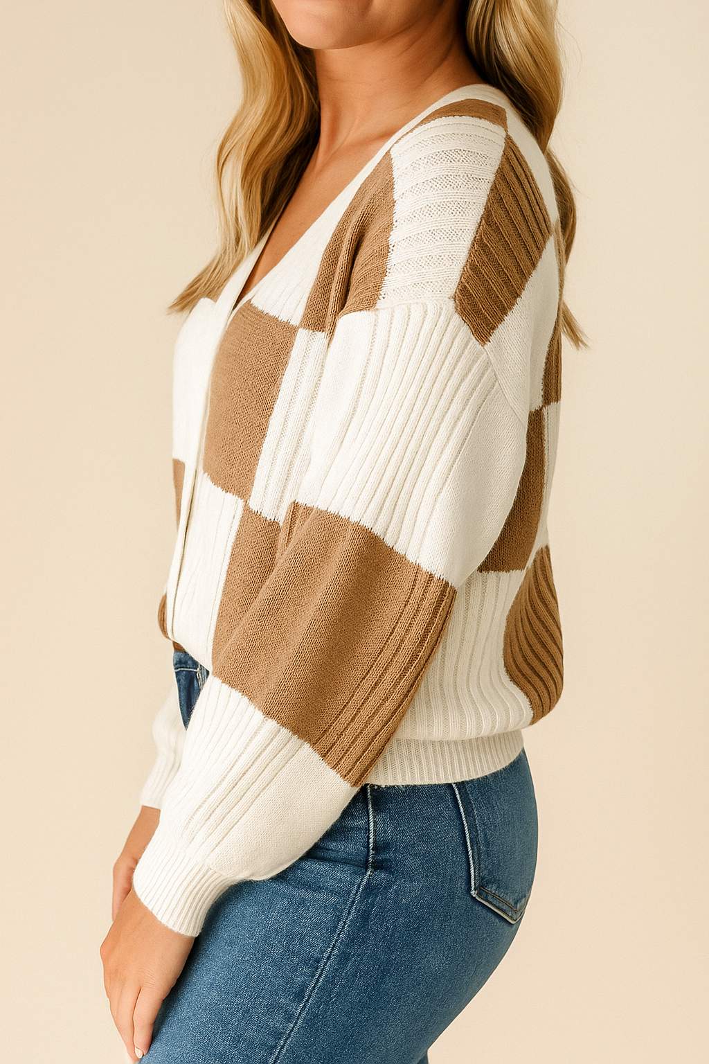 Left side view of the caramel and ivory colorblock knit button-up cardigan highlighting the drop-shoulder sleeve and ribbed cuffs and hem