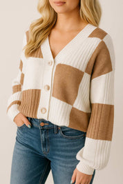 Front three-quarter view of the caramel and ivory colorblock knit V-neck button-up cardigan showing the oversized buttons, drop-shoulder cut and ribbed trims.