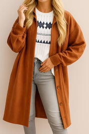 Front view of a women’s caramel textured button-down collared longline coat with drop-shoulder long sleeves and slant welt pockets; rounded straight hem.