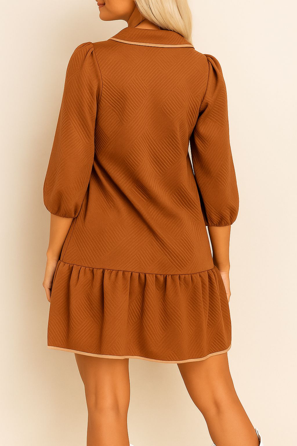 Back view of the chevron-textured mini dress showing the clean collar binding, elastic three-quarter sleeves and the drop-waist ruffle hem that gives the silhouette an easy, relaxed swing.