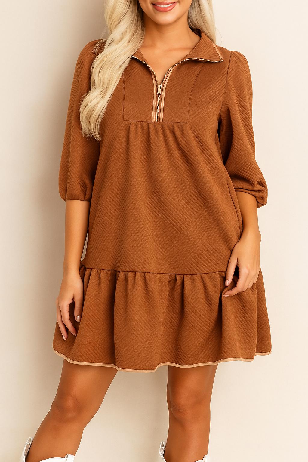 Close front detail of the women’s mini dress highlighting the chevron-textured knit, polo-style half-zip collar and softly gathered panel above the ruffle hem with light, effortless drape.