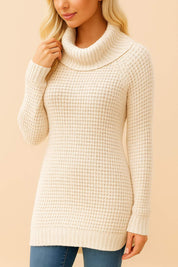 Left three-quarter view of the cream turtleneck waffle-knit tunic sweater highlighting the wide roll neck, long sleeves and textured knit.