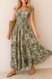 Dark-blue boho-print V-neck cap-sleeve maxi dress with smocked bodice and flowing skirt — front three-quarter view