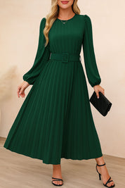 Dark-green belted pleated long-sleeve midi dress with crew neckline and flowing pleat skirt — front three-quarter view