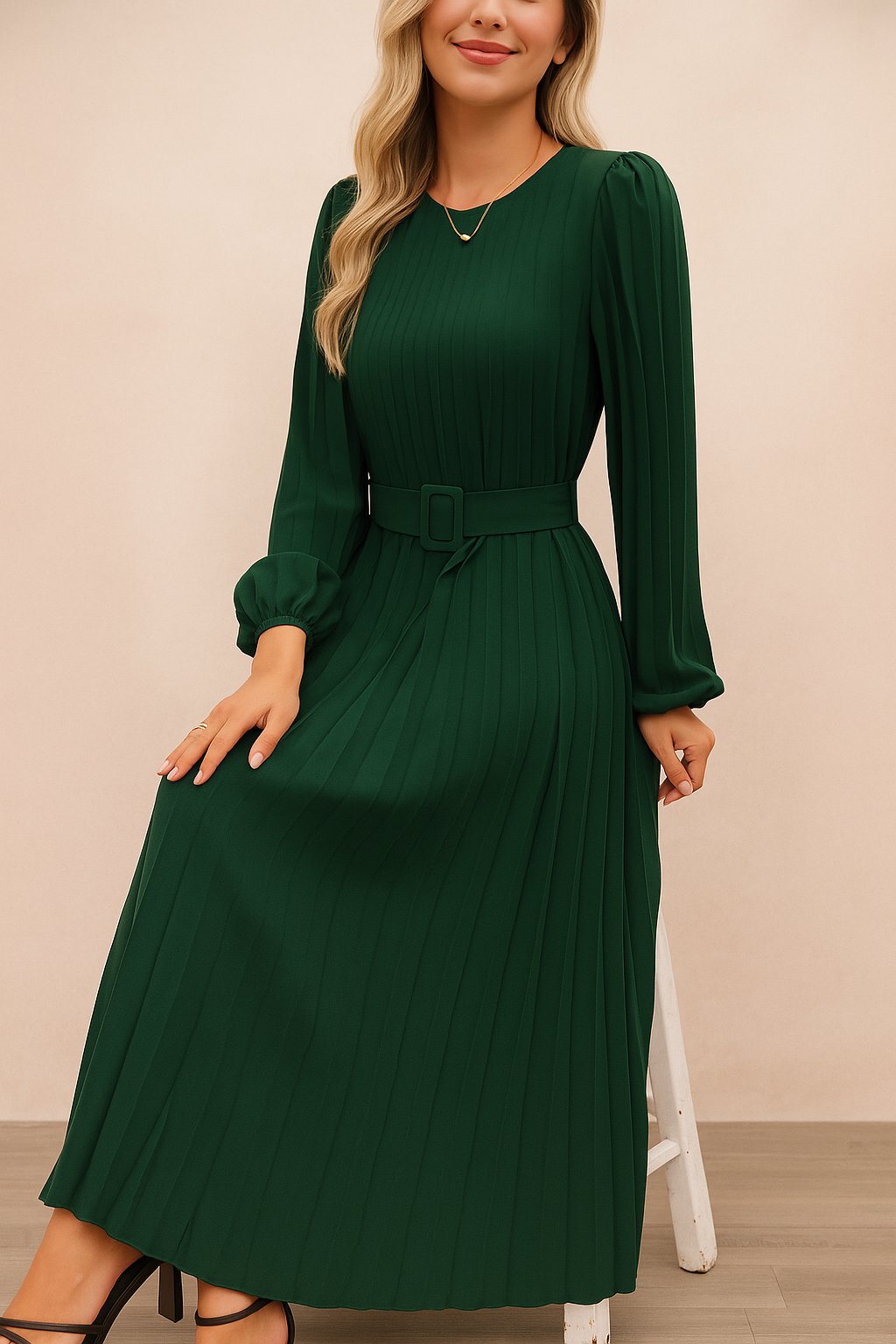 Dark-green belted pleated long-sleeve midi dress with crew neckline and fitted waist — seated front view