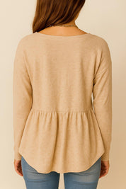 Back view of the dust-storm beige long-sleeve top showing the gathered waist seam and curved back hem.