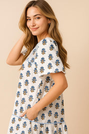 Dusty-blue floral-embroidered babydoll mini dress with puff sleeves, tiered skirt and side-pocket entry — left side view.