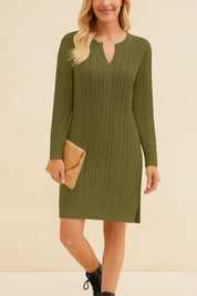 Woman wearing a green cable knit dress with a beige clutch against a beige background