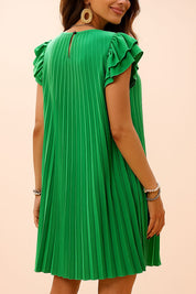 Back view of a green pleated mini dress with ruffle sleeves and keyhole button closure, accessorized with bold earrings and pearl bracelets — elegant summer detail shot.