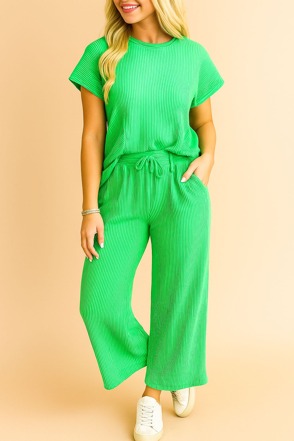 Front detail of the green ribbed knit top highlighting the round neckline and fine rib texture; drawstring waistband and pocket entry partially visible.