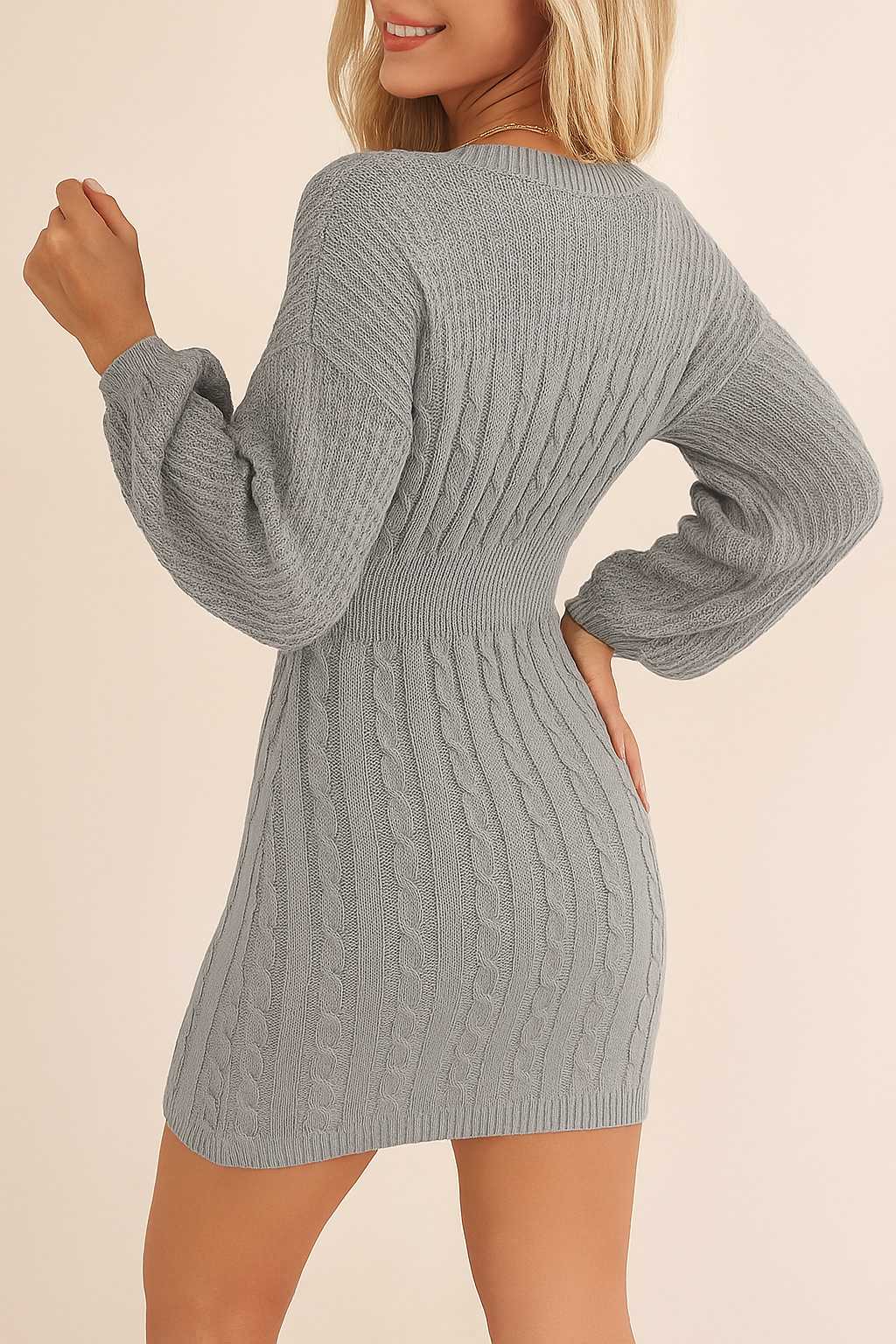 Back view of the cable-knit sweater dress in heather gray with a ribbed waistband, full cable pattern and a clean mini-length hem.