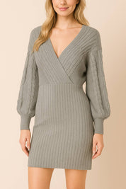 Front view of the women’s ribbed wrap sweater dress in heather gray with a deep V-neck, defined waist and cable-knit balloon sleeves; vertical ribs smooth the silhouette.