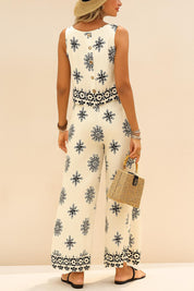 Back view of the beige sleeveless printed top and matching wide-leg pants; button-back detail on the top and border print at the hems
