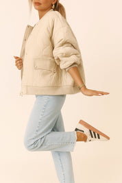 Left side view of the ivory quilted bomber jacket showing rib-knit trims, curved quilting and a snap-flap pocket