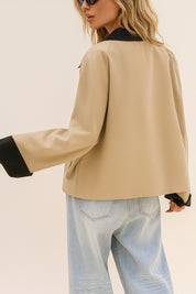 Back three-quarter view of the khaki color-block button-up jacket showing the black contrast collar and cuff accents and straight hem
