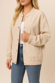 Front three-quarter view of the khaki corduroy snap-button jacket showing the rib-knit collar, button placket and slant welt pockets.