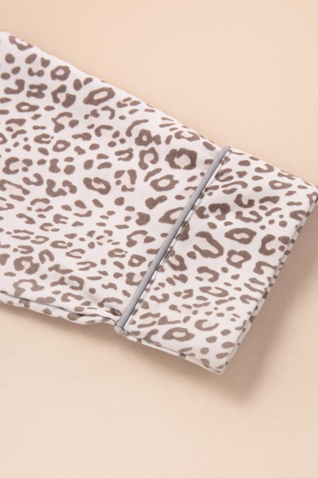 Close-up of leopard print pajama top sleeve with cuff and white piping detail, soft knit fabric for women’s loungewear