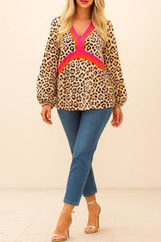 Full-length front view of the leopard-print colorblock V-neck blouse showing the relaxed, flowy silhouette and elastic-cuff sleeves
