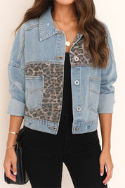 Straight front view of the light-wash denim jacket with leopard-panel inserts, button front, drop-shoulder sleeves and relaxed hem.
