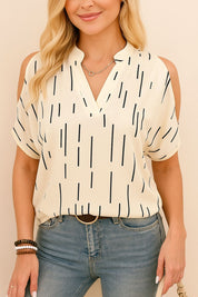 Straight-on front view of the multicolor cold-shoulder notched V-neck blouse styled with jeans; airy woven fabric and clean straight hem.