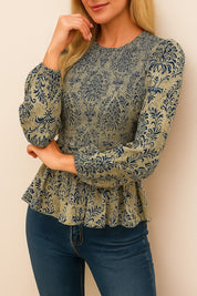 Front view of the navy damask smocked peplum blouse showing the round neck, smocked bodice and gathered hem ruffle; long sleeves with elastic cuffs