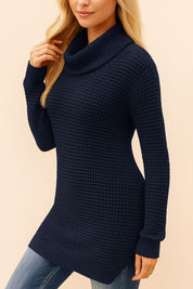 Left three-quarter view of a navy turtleneck waffle-knit tunic sweater with long sleeves, ribbed cuffs and a clean drop-tail hem