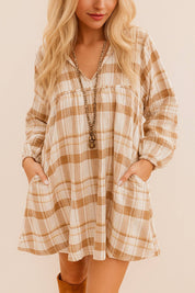 Close-up of a woman in a neutral-tone plaid mini dress featuring long sleeves, soft fabric, and front pockets – perfect for autumn layering