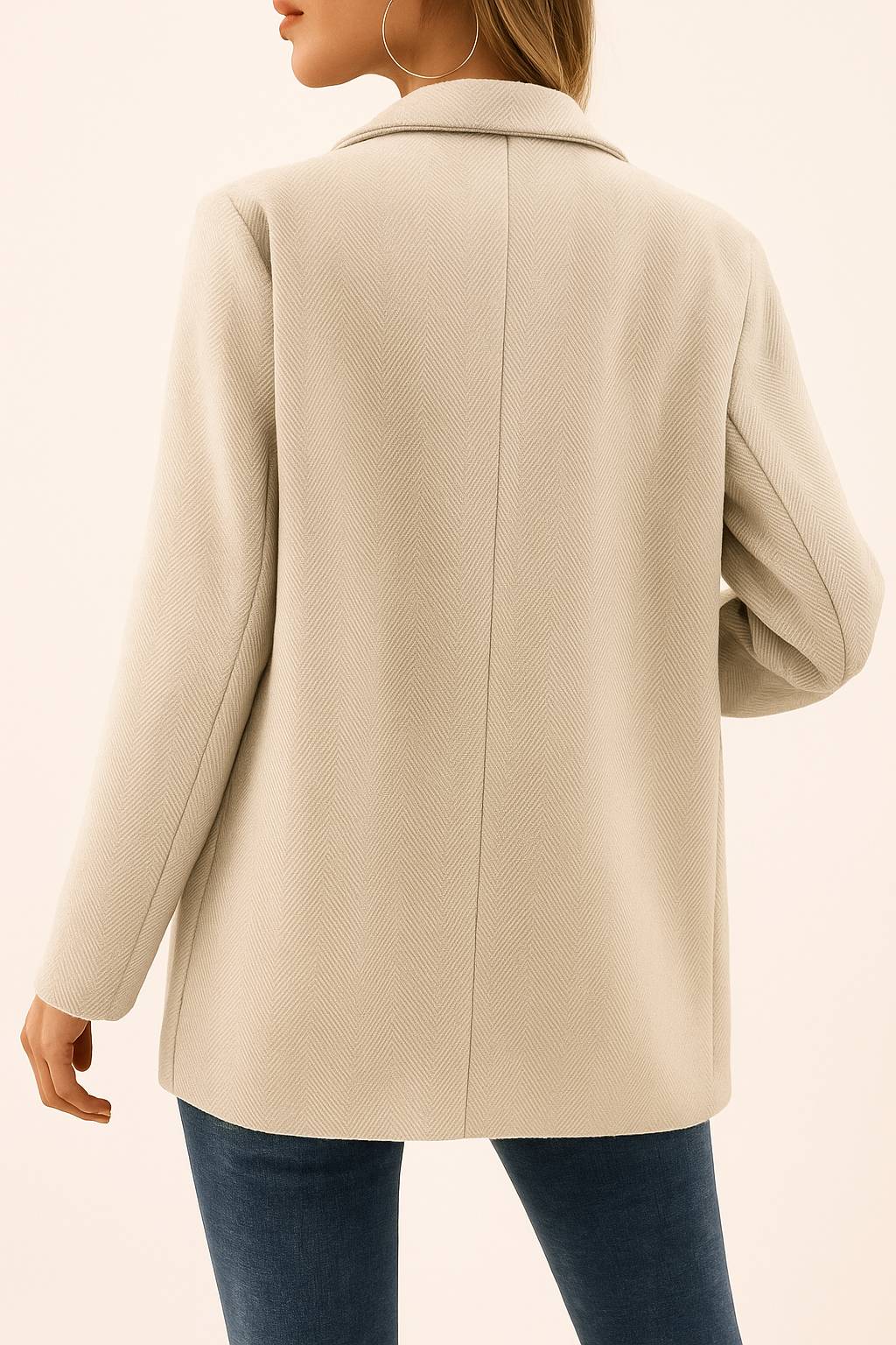 Back view of the oatmeal beige herringbone double-breasted coat with a clean back panel, center seam and straight hem