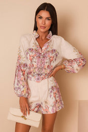 Front view of a pink floral long-sleeve blouse paired with matching belted shorts; relaxed, lightweight woven fabric.
