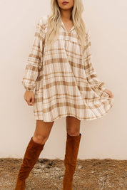 Woman wearing a loose plaid mini dress with long sleeves and v-neckline – styled for a cozy seasonal look
