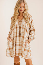 Full outfit view of a woman in a plaid mini dress with puffy sleeves, ankle boots, and a structured handbag – fall fashion inspiration